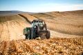 Industrial Tractor with trailer working the corn fields and harvesting during fall season