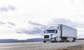 Industrial transportation big rig white semi truck transporting frozen cargo in reefer semi trailer running on the road with Royalty Free Stock Photo