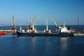 Cargo ship loading at the dock with multiple cranes. Industrial transshipment process in a sea port. Containers being Royalty Free Stock Photo