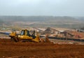 Industrial truck loader excavator moving earth and unloading into a dumper truck and bulldozer is moving ground. View of the large Royalty Free Stock Photo