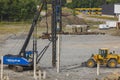 Industrial view on construction site. Pile driving machine driving piles into ground site.