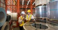 Industrial warehouse scene featuring two safety-conscious men inspecting steel sheet roll stack, imbued with the raw essence of Royalty Free Stock Photo