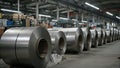 Industrial warehouse with stacked galvanized steel rolls under bright lights Royalty Free Stock Photo