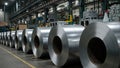 Industrial warehouse with stacked galvanized steel rolls under bright lights Royalty Free Stock Photo