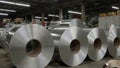 Industrial warehouse with stacked galvanized steel rolls under bright lights Royalty Free Stock Photo
