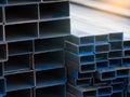 Industrial warehouse stock of rectangular metal pipes for building and construction supplies. Stack of steel pipes. Iron materials Royalty Free Stock Photo