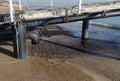 Industrial wastewater, the pipeline discharges liquid industrial waste into the sea on a city beach. Dirty sewage flows from a