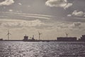 Industrial wharf with wind turbines and ship at sunset