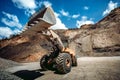 Industrial wheel loader working on construction site. Industrial machinery loading and transporting gravel