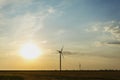 Electric windmill on a sunset background. Alternative energy. Innovative energy producing and manufacturing. Copy space. Royalty Free Stock Photo