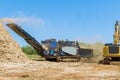 An industrial wood chipper at work with roots for grinding machine to become chip Royalty Free Stock Photo