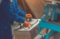 Industrial worker in blue uniform, orange gloves operating control panel with joysticks and buttons Royalty Free Stock Photo