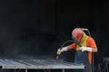 Industrial worker cleaning surface of steel with sandblast