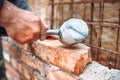 Industrial worker,  construction worker laying bricks and building walls on construction site. Detail of hand adjusting bricks Royalty Free Stock Photo