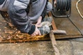 Industrial worker cutting a metal square tube with a manual electric grinder Royalty Free Stock Photo