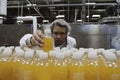 Industrial worker examining bottle in factory