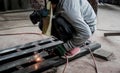 Industrial Worker at the factory welding closeup. Electric wheel grinding on steel structure in factory. Royalty Free Stock Photo