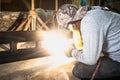 Industrial Worker at the factory welding closeup. Electric wheel grinding on steel structure in factory. Royalty Free Stock Photo