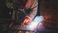 Industrial Worker at the factory welding closeup. Electric wheel grinding on steel structure in factory.