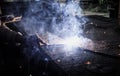 Industrial Worker at the factory welding closeup. Electric wheel grinding on steel structure in factory.