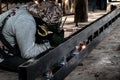 Industrial Worker at the factory welding closeup. Electric wheel grinding on steel structure in factory.