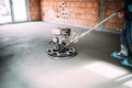 Industrial worker finishes concrete screed with trowel machine Royalty Free Stock Photo