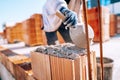 Bricklayer industrial worker installing brick masonry on exterior wall with trowel putty knife Royalty Free Stock Photo