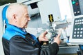 Industrial worker measuring detail near cnc milling machine Royalty Free Stock Photo