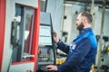 Industrial worker operating cnc machine at metal machining industry Royalty Free Stock Photo