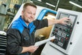 Industrial worker operating cnc turning machine in metal machining industry Royalty Free Stock Photo