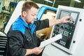 Industrial worker operating cnc turning machine in metal machining industry Royalty Free Stock Photo