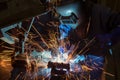 Industrial worker is welding repair metal part in car factory