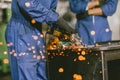 Industrial Worker Using Angle Grinder and Cutting a Metal Sheet. Contractor in Safety Uniform and Hard Hat Manufacturing Metal Royalty Free Stock Photo