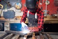 Industrial worker welder with protective mask and point tool work in factory. Sparks from high electricity