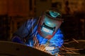 Industrial worker is welding assembly automotive part in car factory