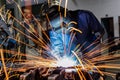 Industrial worker is welding in construction plant