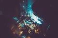 Industrial worker welding round pipe on a work table, producing blue smoke, yellow sparks and reflections