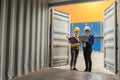 Industrial worker woman and engineer control worker checking in front door of cargo container at container cargo harbor Royalty Free Stock Photo