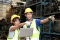 Portrait of industrial workers and senior foreman wearing safety vest and helmet, standing with arms crossed together at Royalty Free Stock Photo