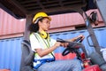 Industrial worker woman wearing safety vest and helmet driving forklift car at factory industry, beautiful African American female Royalty Free Stock Photo