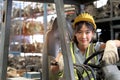 Industrial worker woman wearing safety vest and helmet driving forklift car at manufacturing plant factory industry. Asian Royalty Free Stock Photo