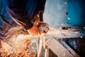 Industrial workers hands cutting iron with angle grinder. Factory production details