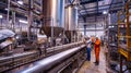 Industrial workers inspecting machinery in a modern factory plant Royalty Free Stock Photo