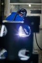 Industrial workers welding metal with many sharp sparks