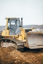 Industrial yellow bulldozer leveling earth
