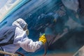 Spray painting the hull of a sailing yacht