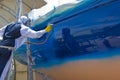 Spray painting the hull of a sailing yacht