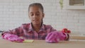 Industrious african girl polishing kitchen table