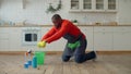 Industrious african male wiping floor at home