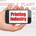 Industry concept: Hand Holding Smartphone with Printing Industry on display Royalty Free Stock Photo